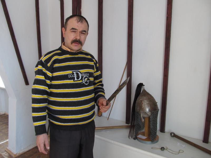 Викладач та керівник гуртка Микола Михайлов демонструє зброю та обладунки, виготовлені його учнями.
