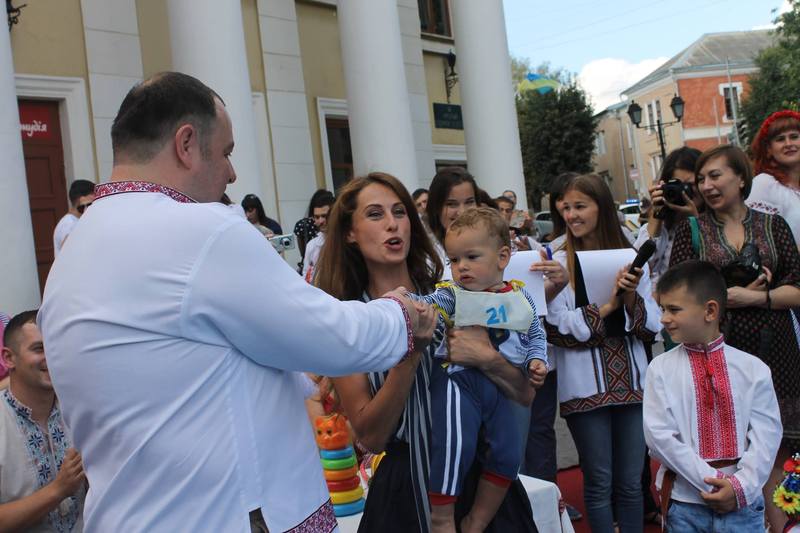 Переможець змагань малюків Гліб Чумагін з мамою та сестрою отримують подарунки від заступника міського голови Вадима Савчука