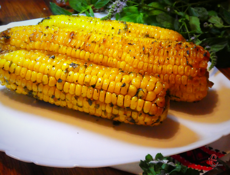 Кукурудза, запечена в духовці, виходить дуже ароматною за рахунок свіжої зелені, спецій і часнику, соковитою - завдяки маслу. 